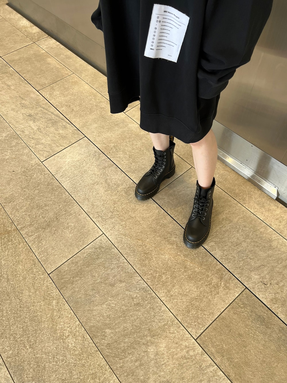 ブラック系のブーツ、ブラック系のスウェットを着用したレディースの夏コーディネートの2枚目の写真
