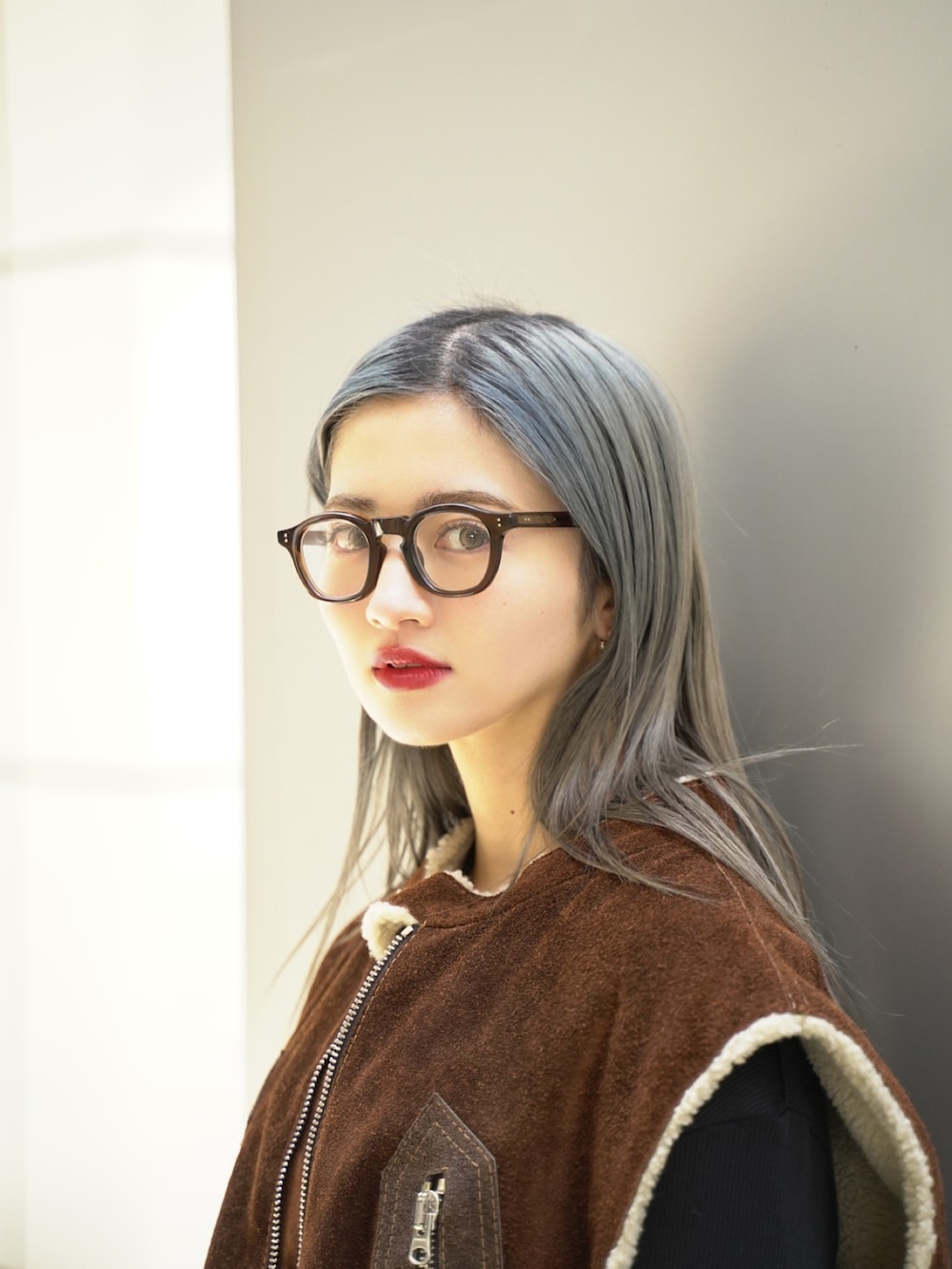 ブラウン系のベスト、グレー系のスラックス、ホワイト系のローファーを着用したレディースの冬コーディネートの3枚目の写真