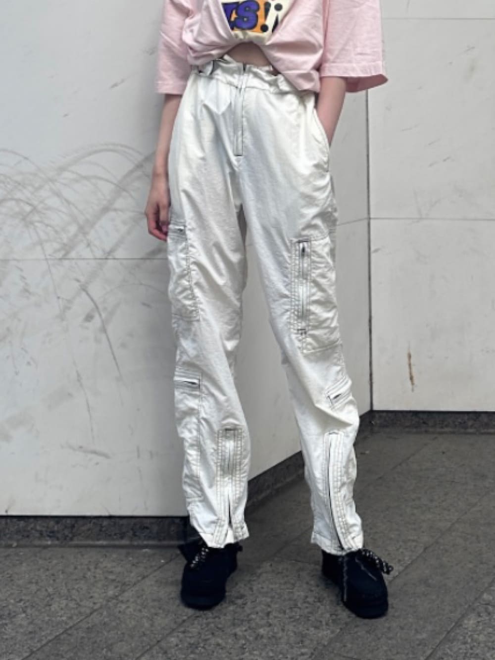 ホワイト系のパンツ、ブラック系のモカシン/デッキシューズ、ピンク系のTシャツ/カットソーを着用したレディースの夏コーディネートの2枚目の写真