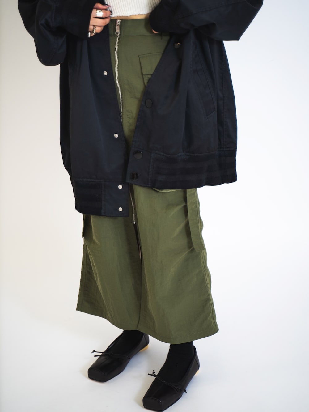 ホワイト系のキャミソール、ブラック系のMA-1、グリーン系のスカートを着用したレディースの夏コーディネートの4枚目の写真