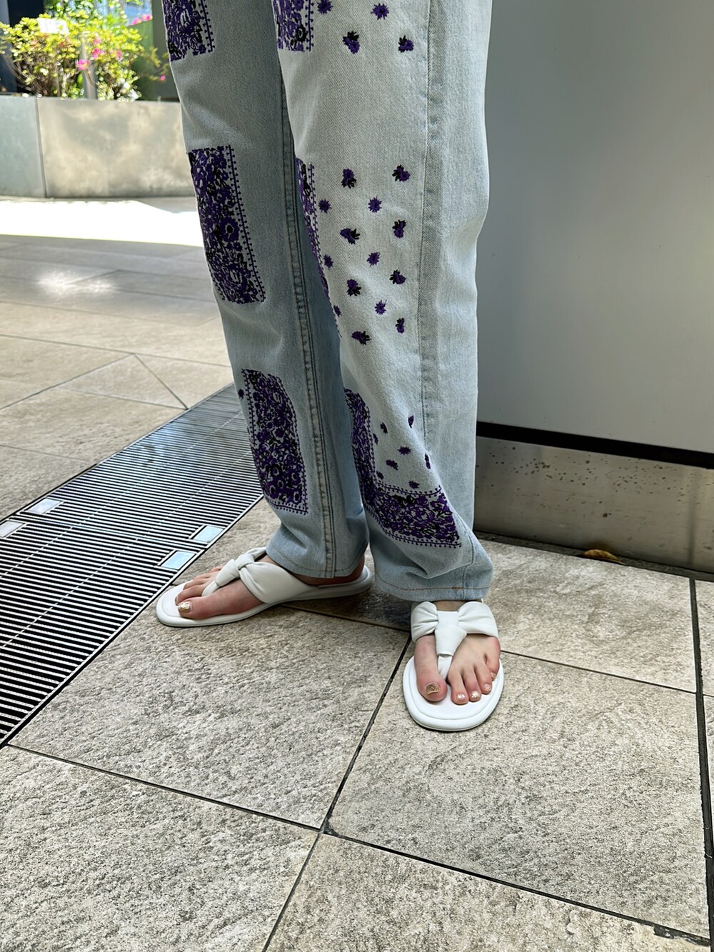 ブラック系のTシャツ/カットソー、パープル系のデニムパンツ、ホワイト系のサンダルを着用したレディースの春コーディネートの3枚目の写真