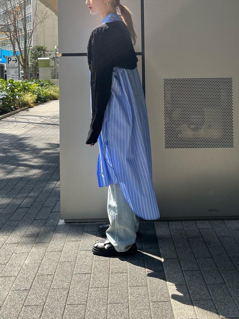 ブルー系のシャツワンピース、ブラック系のカーディガン/ボレロ、グリーン系のショルダーバッグを着用したレディースの春コーディネートの3枚目の写真