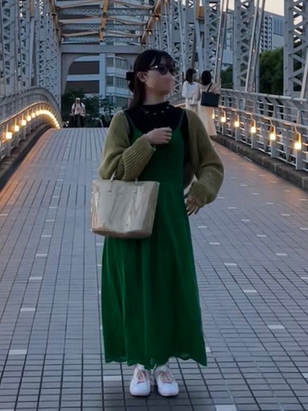 シルバー系のハンドバッグ、イエロー系のカーディガン/ボレロ、グリーン系のワンピースを着用したレディースの春コーディネートの2枚目の写真