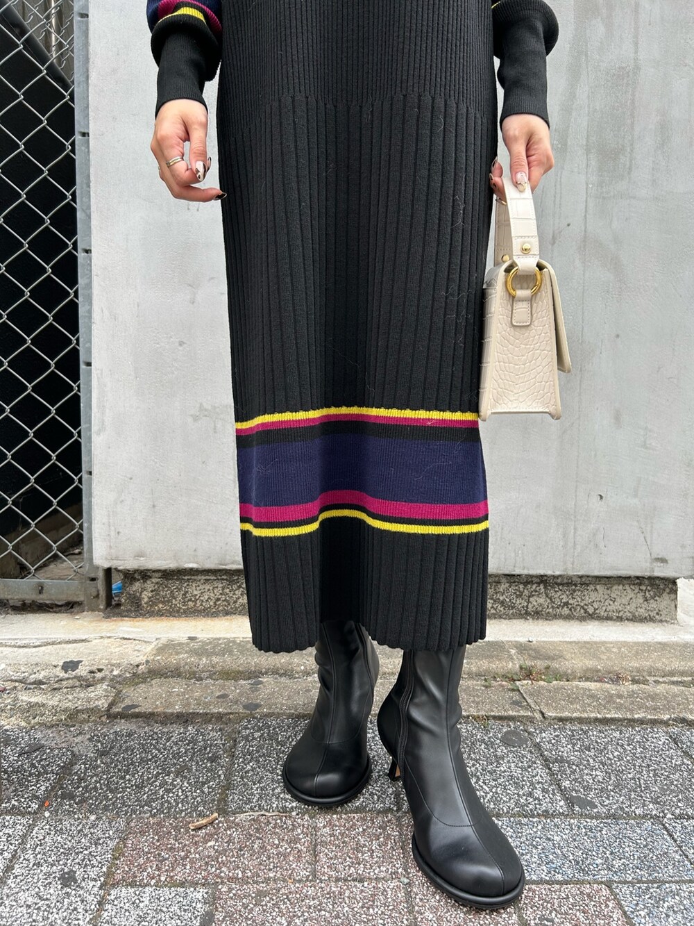 ホワイト系のベスト、ブラック系のワンピースを着用したレディースの秋コーディネートの4枚目の写真