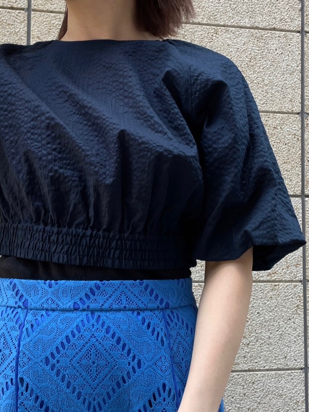 ブルー系のスカート、ブルー系のシャツ/ブラウス、ホワイト系のハンドバッグを着用したレディースの春コーディネートの4枚目の写真