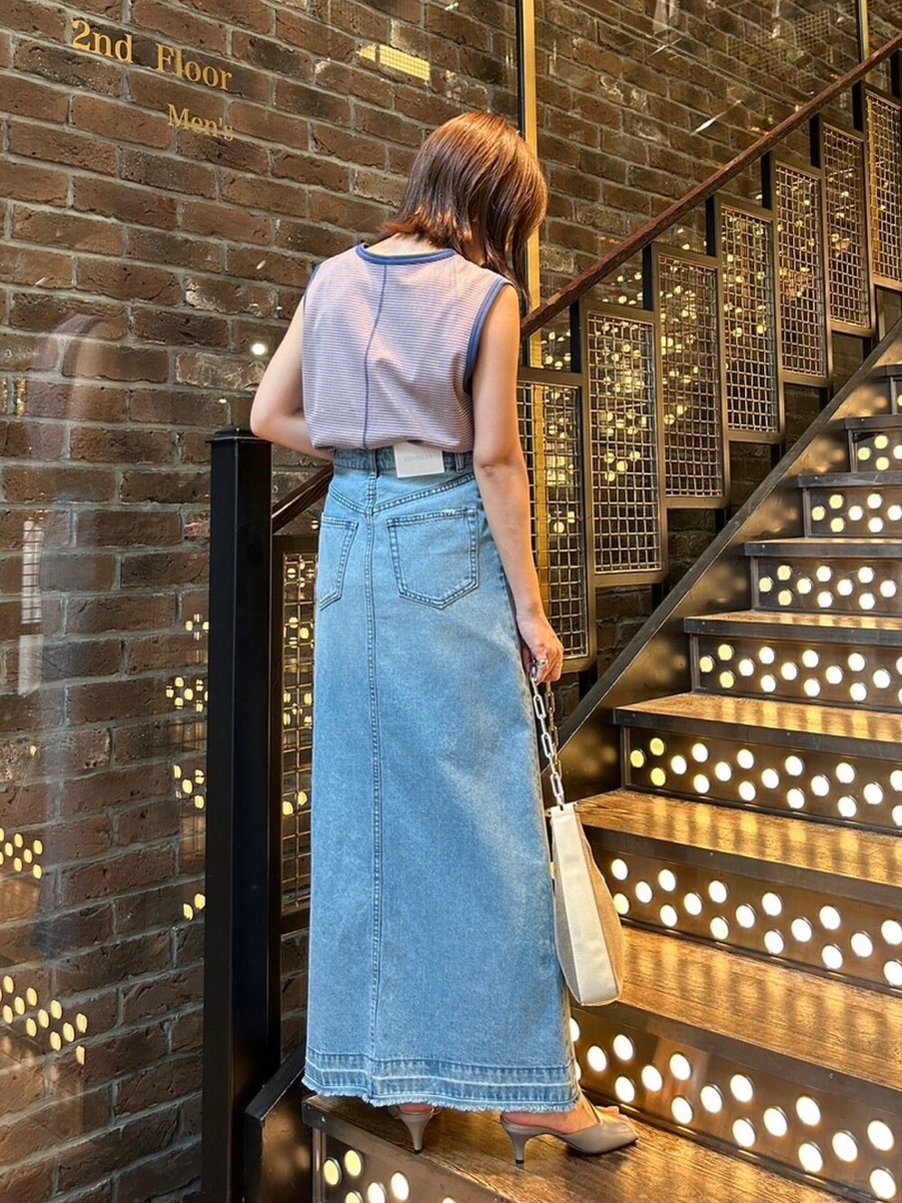 ブルー系のタンクトップ、ブルー系のデニムスカート、グレー系のシューズを着用したレディースの夏コーディネートの2枚目の写真