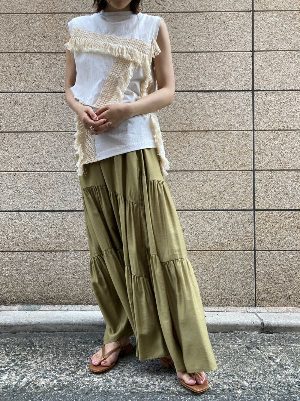 ホワイト系のトップス、グリーン系のスカート、ブラウン系のサンダルを着用したレディースの夏コーディネートの3枚目の写真