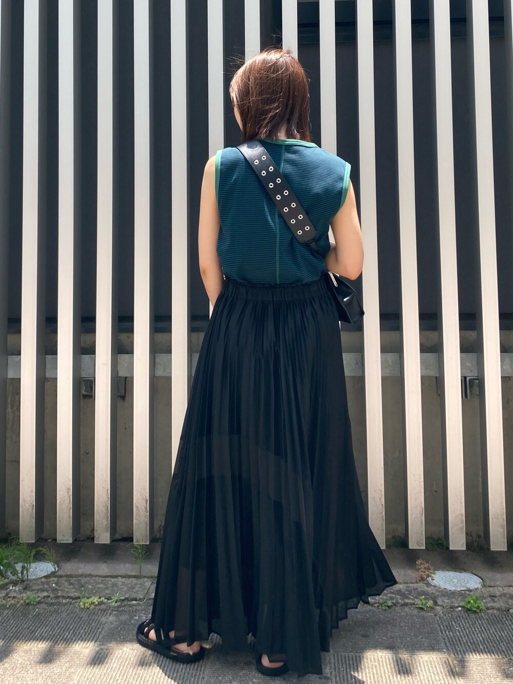 ブラック系のスカート、ブラック系のサンダル、ブラック系のショルダーバッグを着用したレディースの夏コーディネートの4枚目の写真