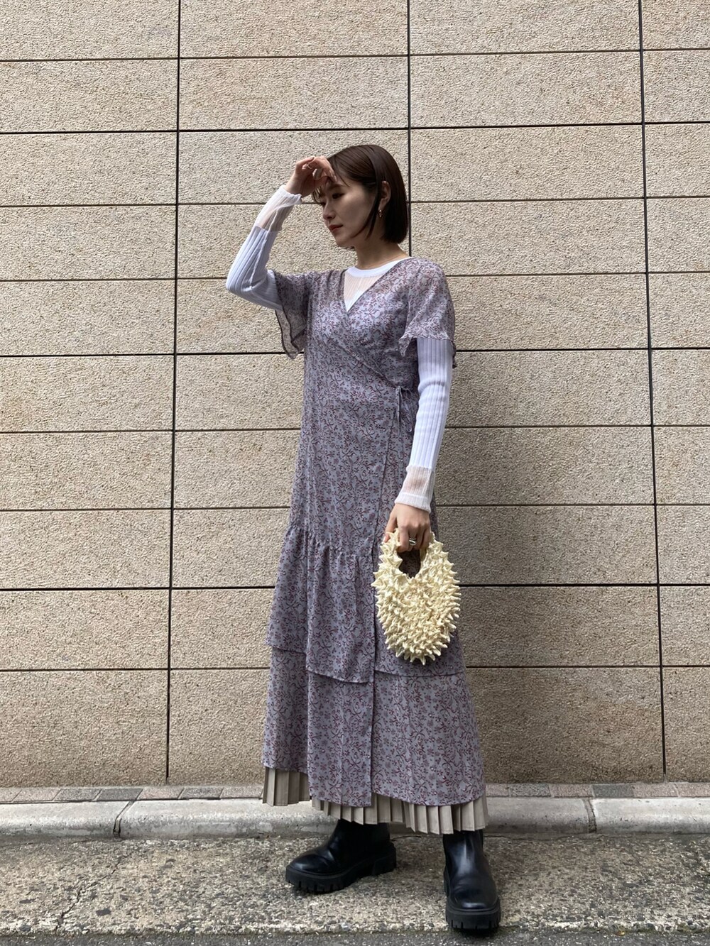 イエロー系のバッグ、グレー系のワンピース/ドレス、パープル系のテーラードジャケットを着用したレディースの冬コーディネートの3枚目の写真