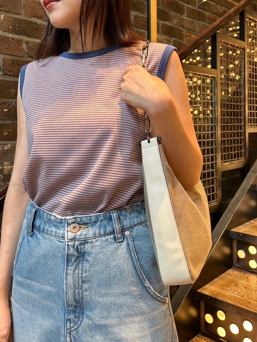 ブルー系のタンクトップ、ブルー系のデニムスカート、グレー系のシューズを着用したレディースの夏コーディネートの3枚目の写真