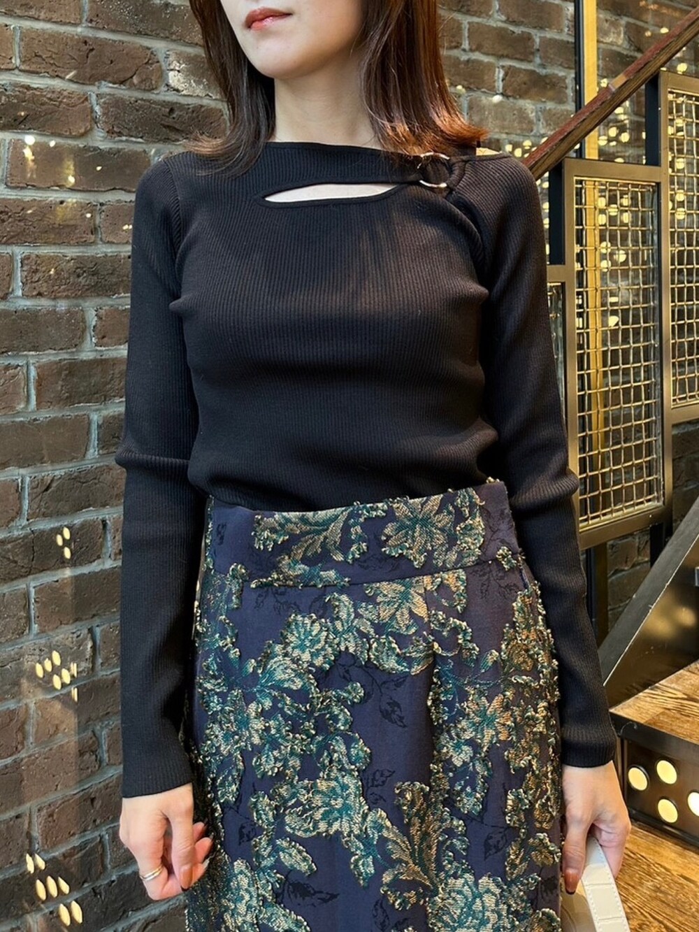 ホワイト系のブルゾン、ブルー系のスカート、ブラック系のニット/セーターを着用したレディースの秋コーディネートの4枚目の写真