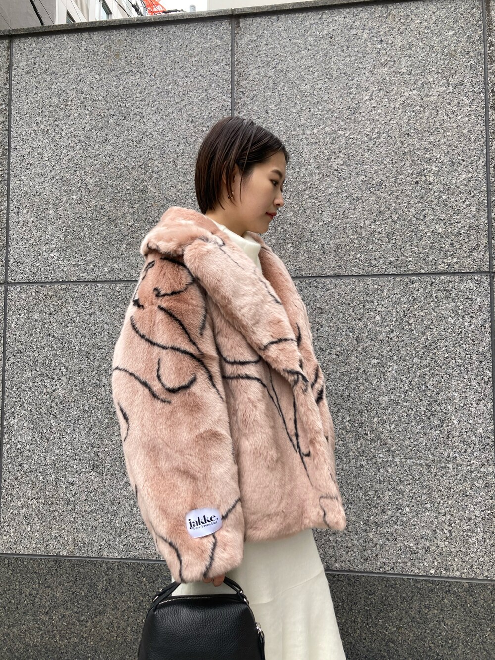 ホワイト系のトップス、ピンク系のその他アウター、ブラック系のショルダーバッグを着用したレディースの秋コーディネートの3枚目の写真