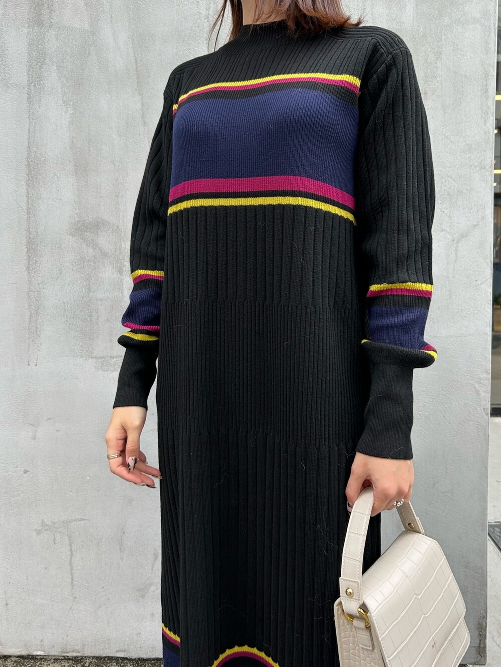 ホワイト系のベスト、ブラック系のワンピースを着用したレディースの秋コーディネートの3枚目の写真