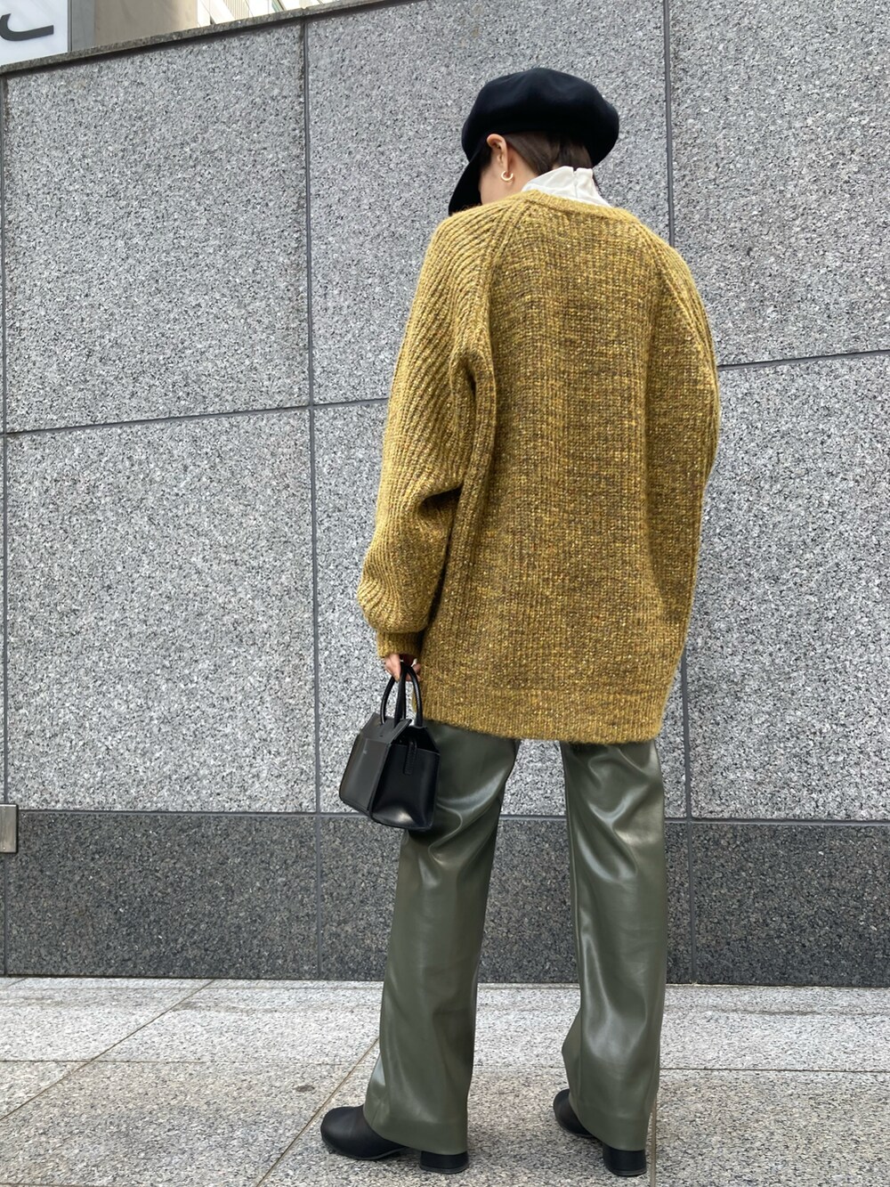イエロー系のニット/セーター、ブラック系のショルダーバッグ、グリーン系のその他パンツを着用したレディースの秋コーディネートの4枚目の写真