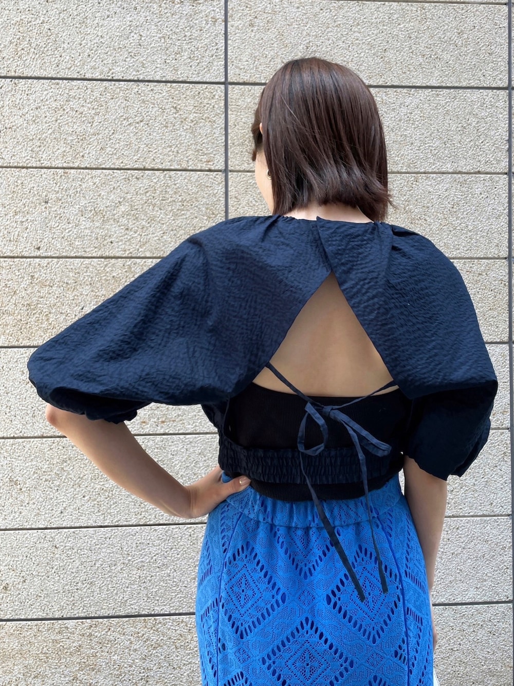 ブルー系のスカート、ブルー系のシャツ/ブラウス、ホワイト系のハンドバッグを着用したレディースの春コーディネートの2枚目の写真