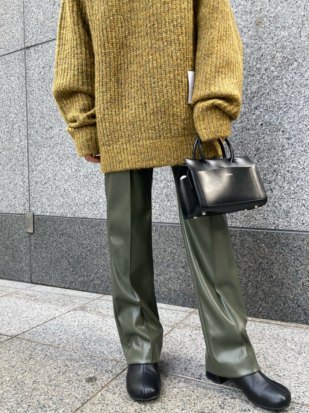 イエロー系のニット/セーター、ブラック系のショルダーバッグ、グリーン系のその他パンツを着用したレディースの秋コーディネートの3枚目の写真