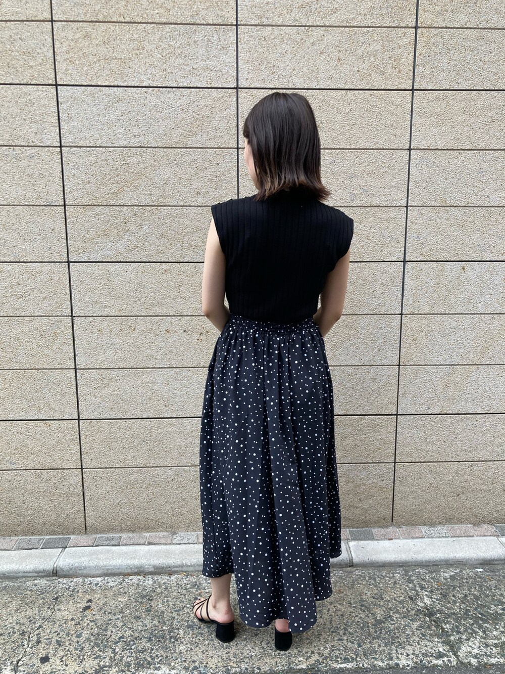 ブラック系のワンピース、ホワイト系のショルダーバッグ、ブラック系のサンダルを着用したレディースの夏コーディネートの4枚目の写真