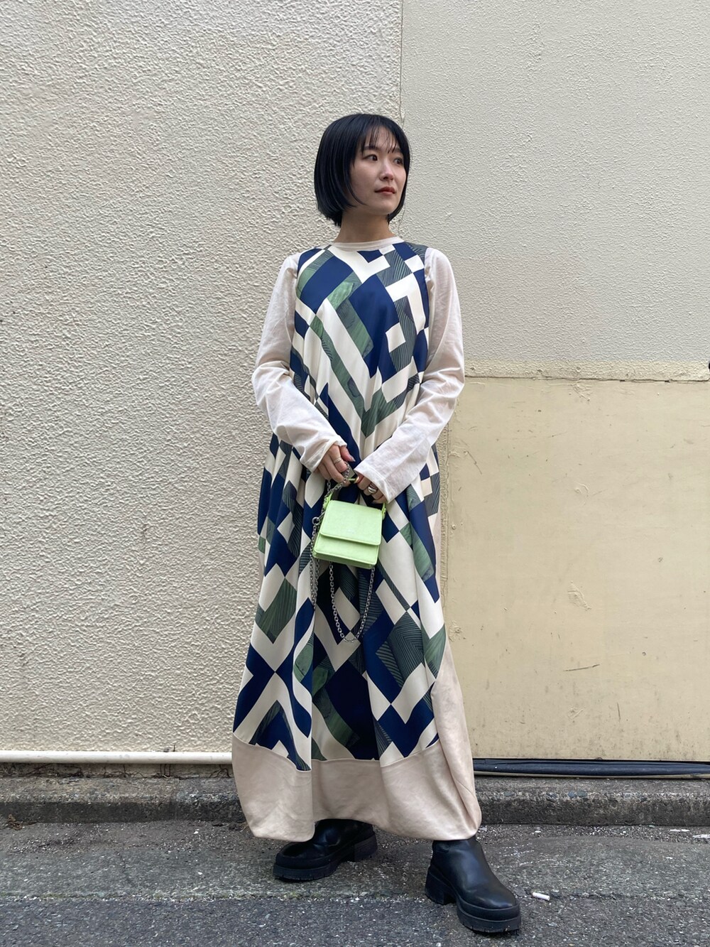 ブラウン系のトレンチコート、グリーン系のワンピース/ドレスを着用したレディースの冬コーディネートの3枚目の写真