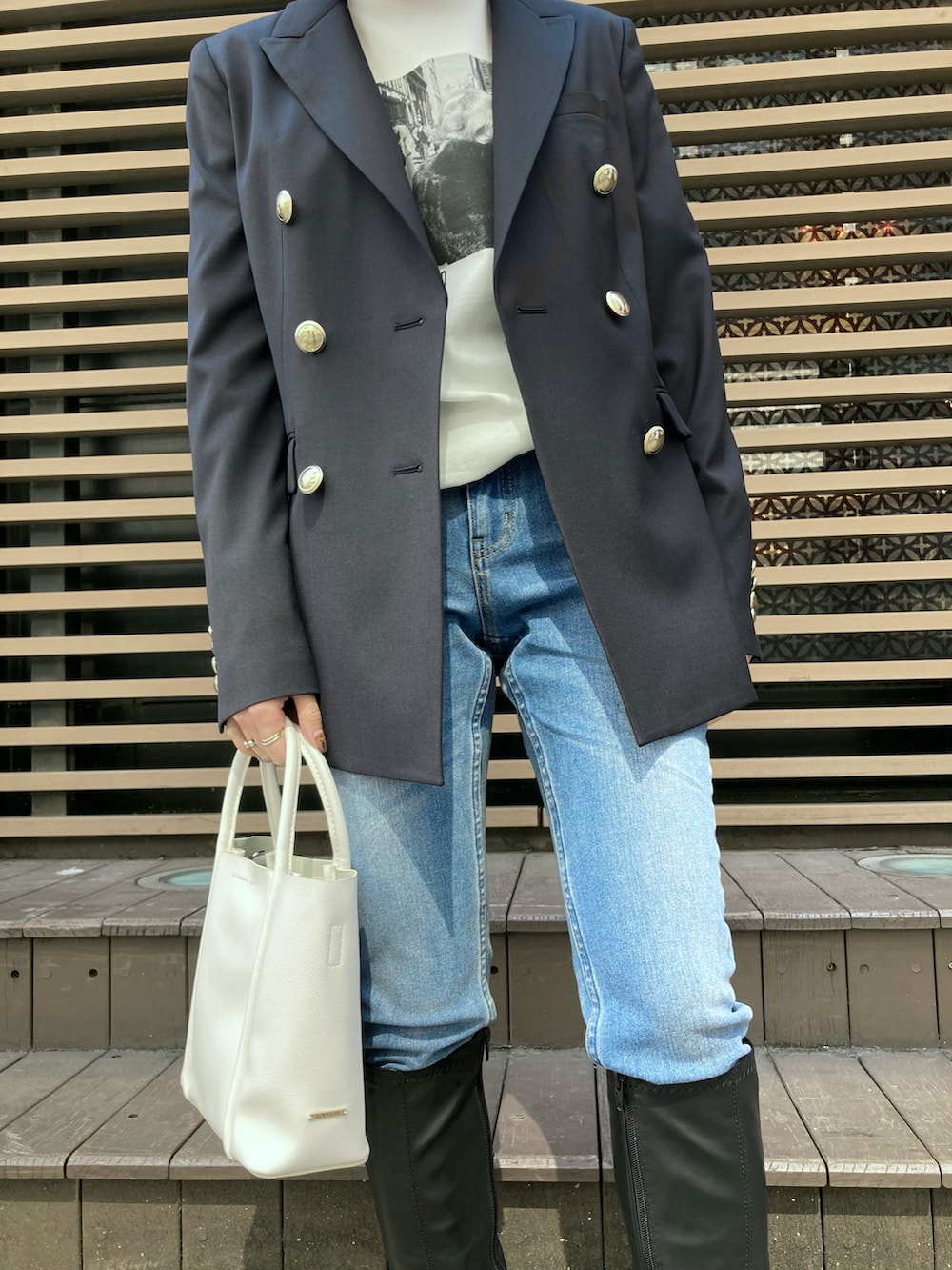 ホワイト系のTシャツ/カットソー、ブルー系のテーラードジャケット、ブルー系のデニムパンツを着用したレディースの春コーディネートの3枚目の写真