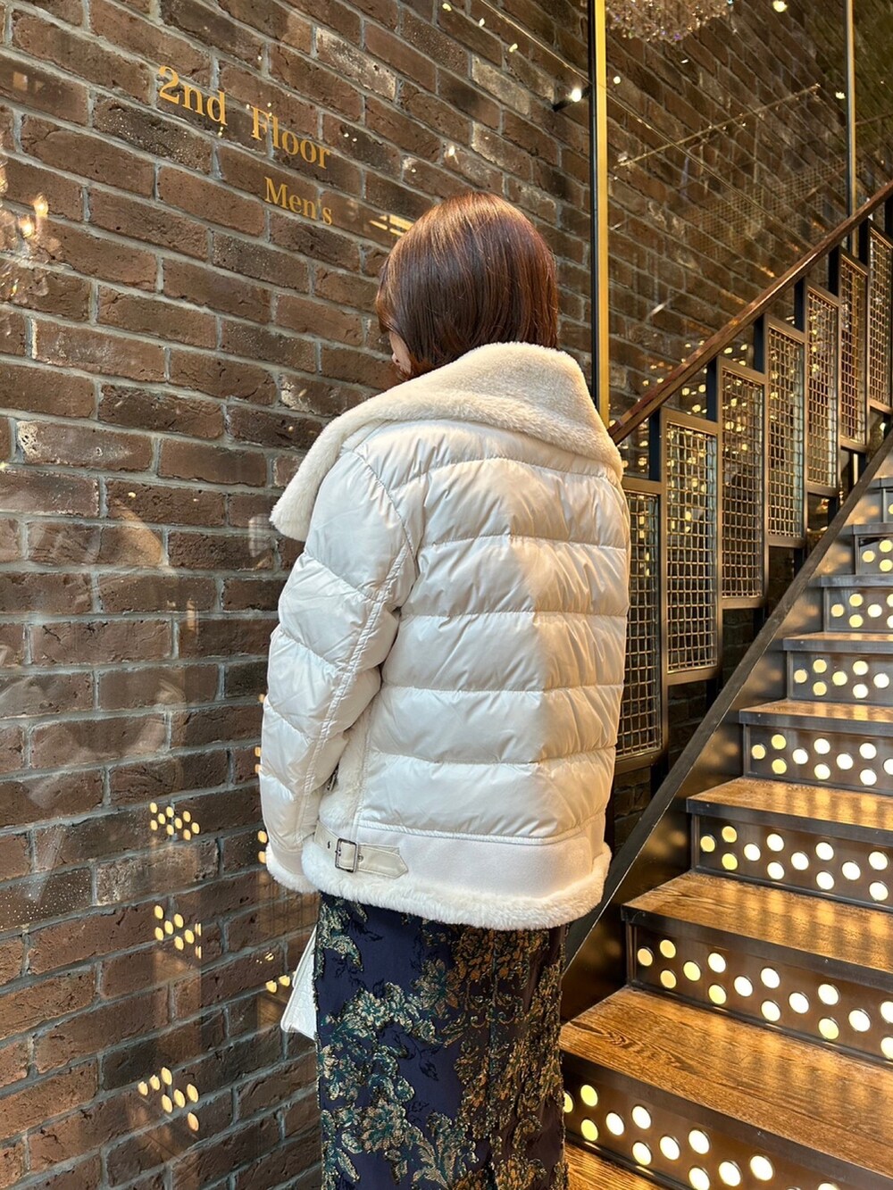 ホワイト系のブルゾン、ブルー系のスカート、ブラック系のニット/セーターを着用したレディースの秋コーディネートの3枚目の写真