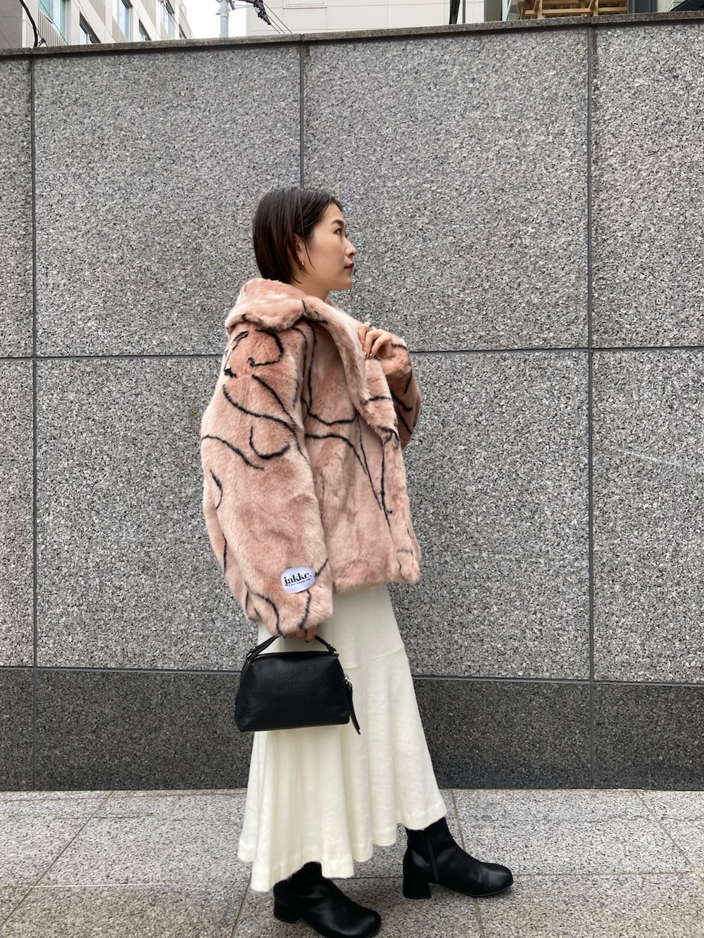 ホワイト系のトップス、ピンク系のその他アウター、ブラック系のショルダーバッグを着用したレディースの秋コーディネートの2枚目の写真