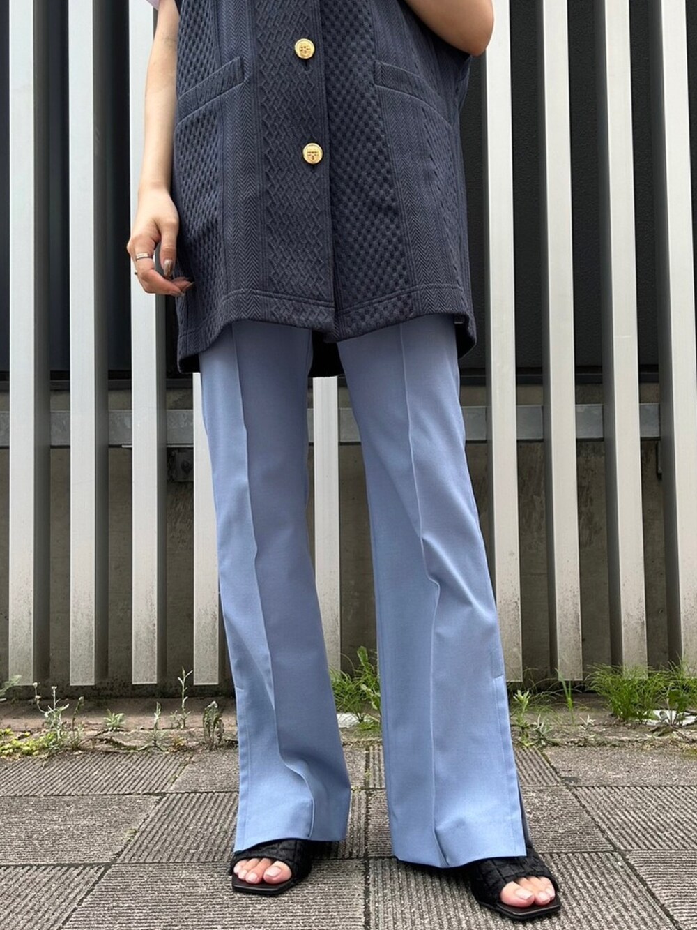 ホワイト系のハンドバッグ、ブルー系のベスト、ブルー系のその他パンツを着用したレディースの夏コーディネートの4枚目の写真