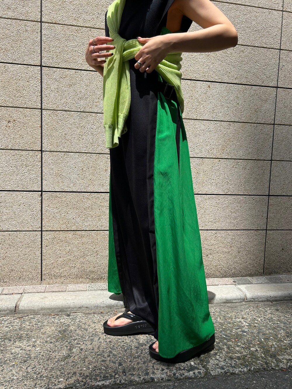 ブラック系のサンダル、グリーン系のカーディガン/ボレロ、グリーン系のワンピースを着用したレディースの春コーディネートの3枚目の写真