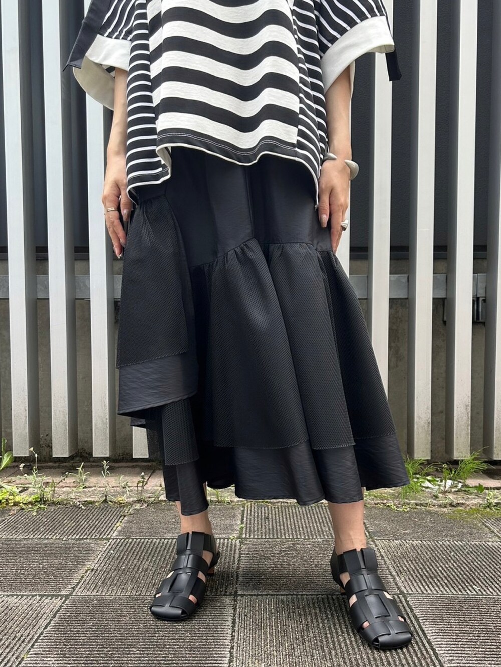 ブラック系のスカート、ブラック系のサンダル、ブラック系のTシャツ/カットソーを着用したレディースの夏コーディネートの4枚目の写真