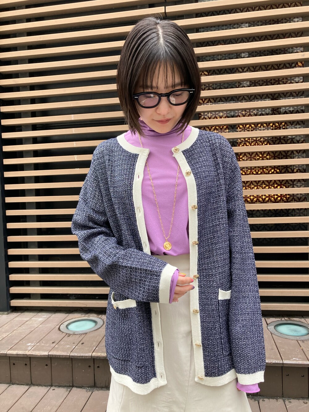 パープル系のその他トップス、ブルー系のカーディガン/ボレロ、ベージュ系のスカートを着用したレディースの春コーディネートの2枚目の写真