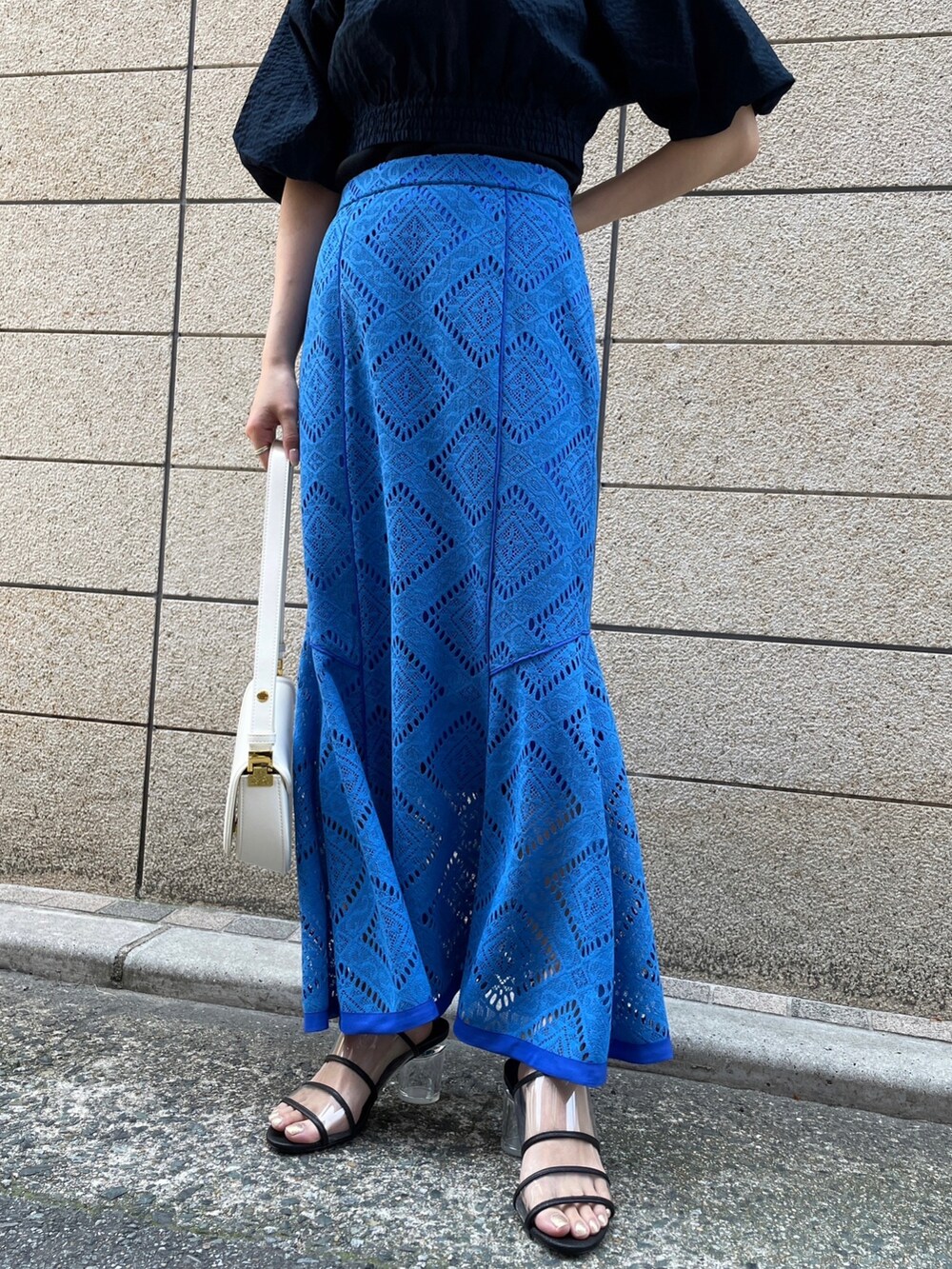 ブルー系のスカート、ブルー系のシャツ/ブラウス、ホワイト系のハンドバッグを着用したレディースの春コーディネートの3枚目の写真