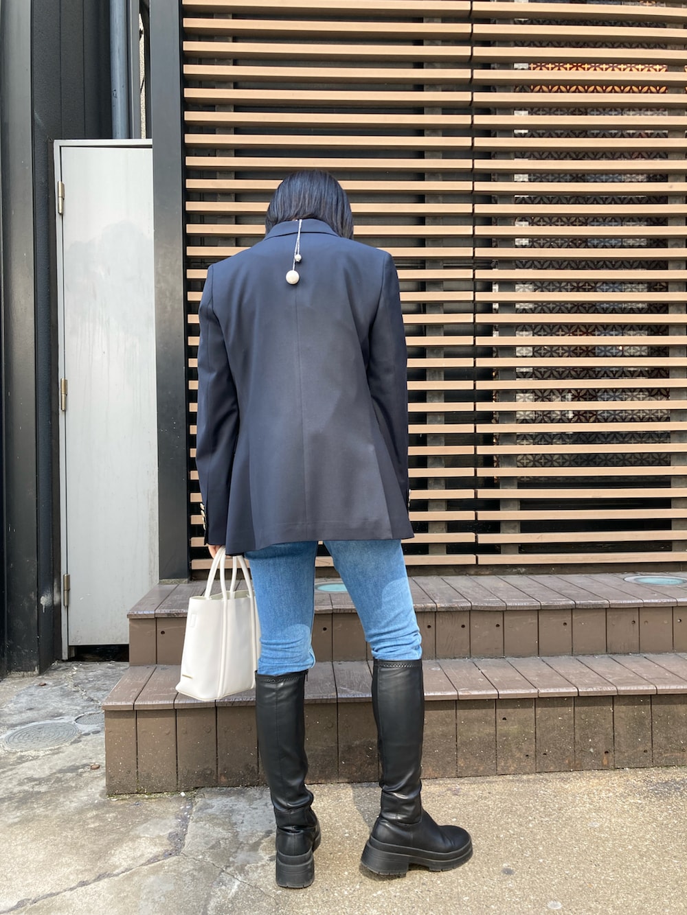 ホワイト系のTシャツ/カットソー、ブルー系のテーラードジャケット、ブルー系のデニムパンツを着用したレディースの春コーディネートの5枚目の写真