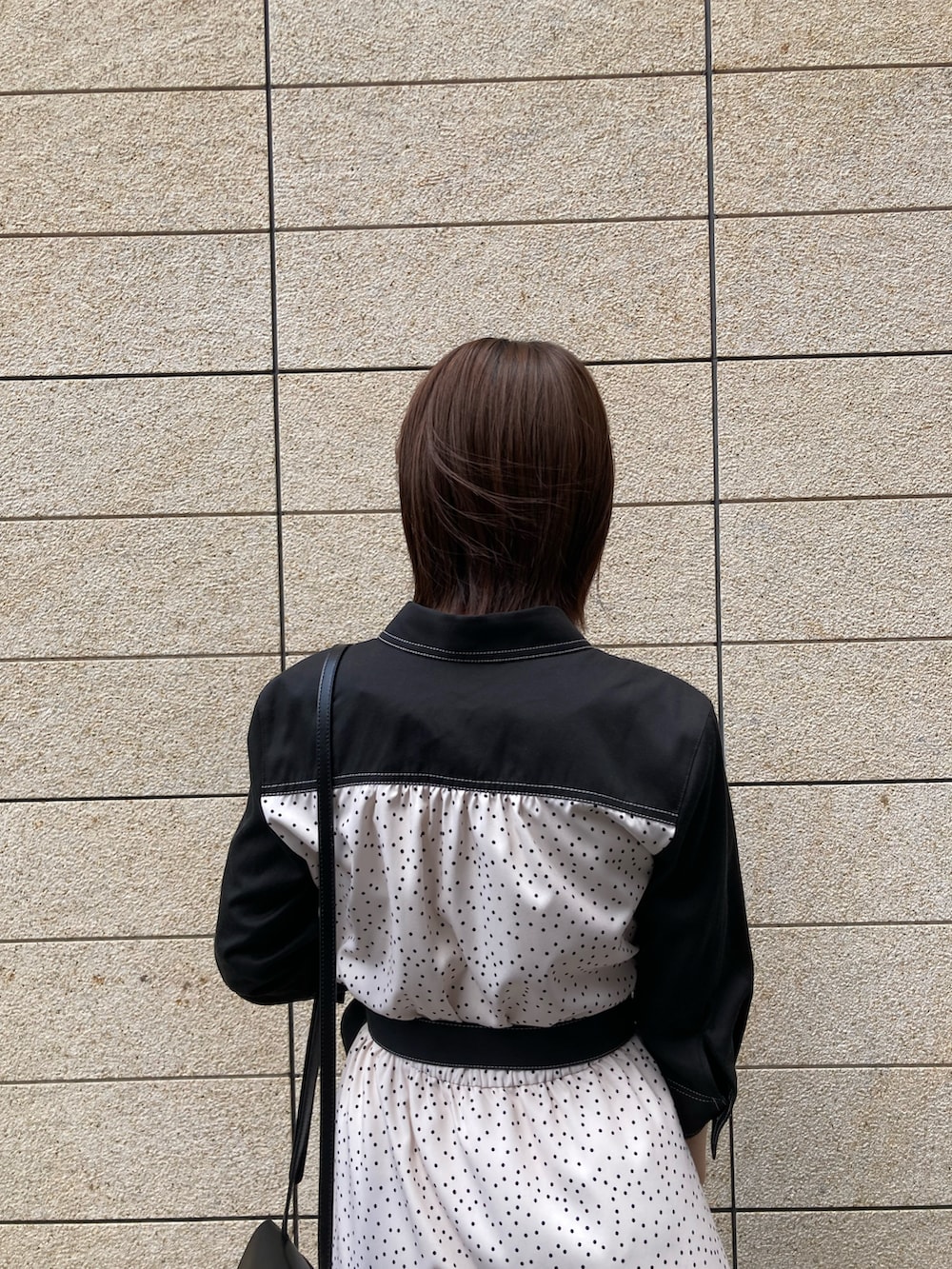 ブラック系のシャツワンピース、ブラック系のショルダーバッグ、ブラック系のブーツを着用したレディースの春コーディネートの5枚目の写真