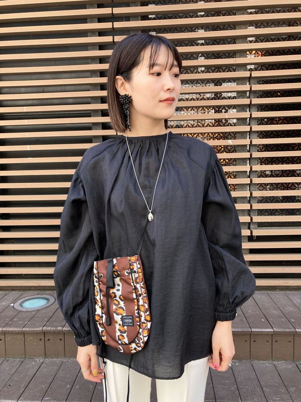 ブラック系のシャツ/ブラウス、ブラウン系のショルダーバッグ、ホワイト系のその他パンツを着用したレディースの春コーディネートの2枚目の写真