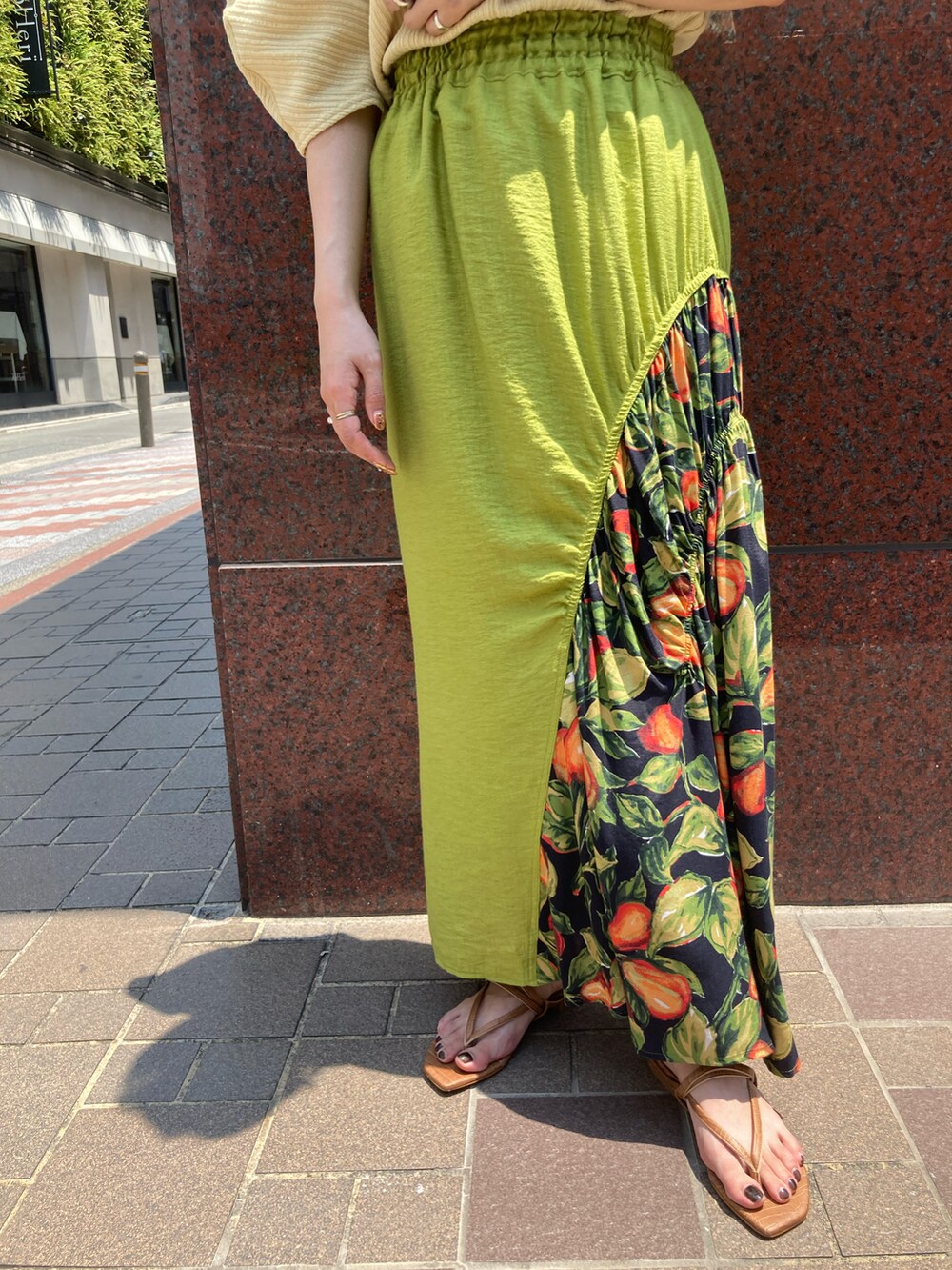 イエロー系のTシャツ/カットソー、オレンジ系のスカート、ブラウン系のサンダルを着用したレディースの春コーディネートの4枚目の写真