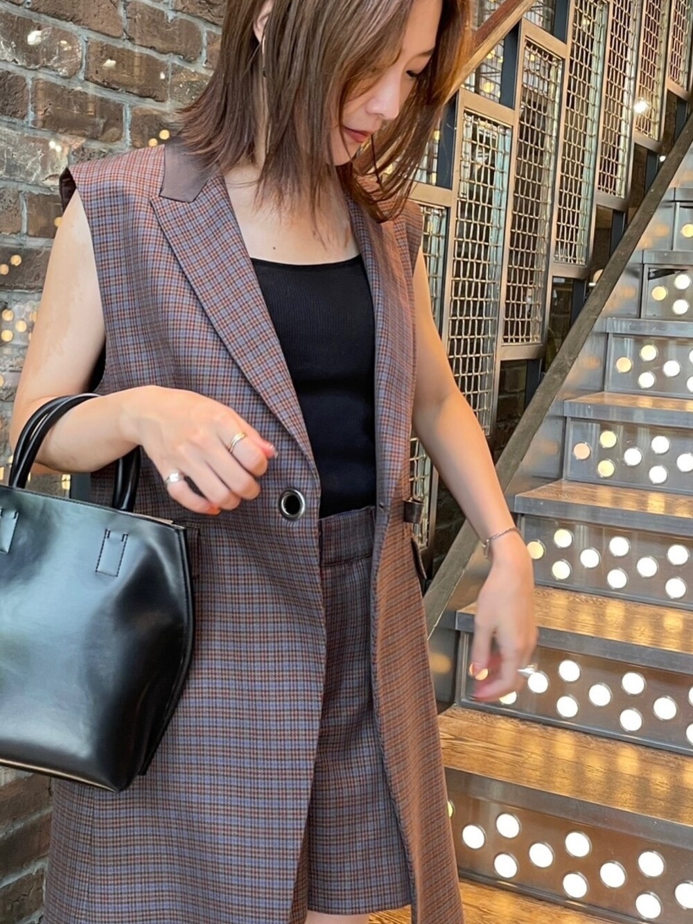 ブラウン系のベスト、ブラウン系のその他パンツ、ブラック系のトートバッグを着用したレディースの夏コーディネートの2枚目の写真