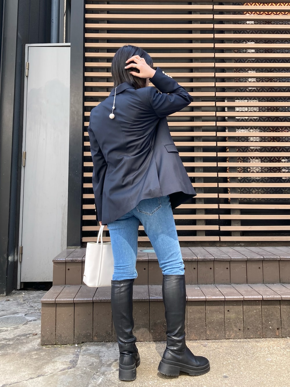 ホワイト系のTシャツ/カットソー、ブルー系のテーラードジャケット、ブルー系のデニムパンツを着用したレディースの春コーディネートの4枚目の写真