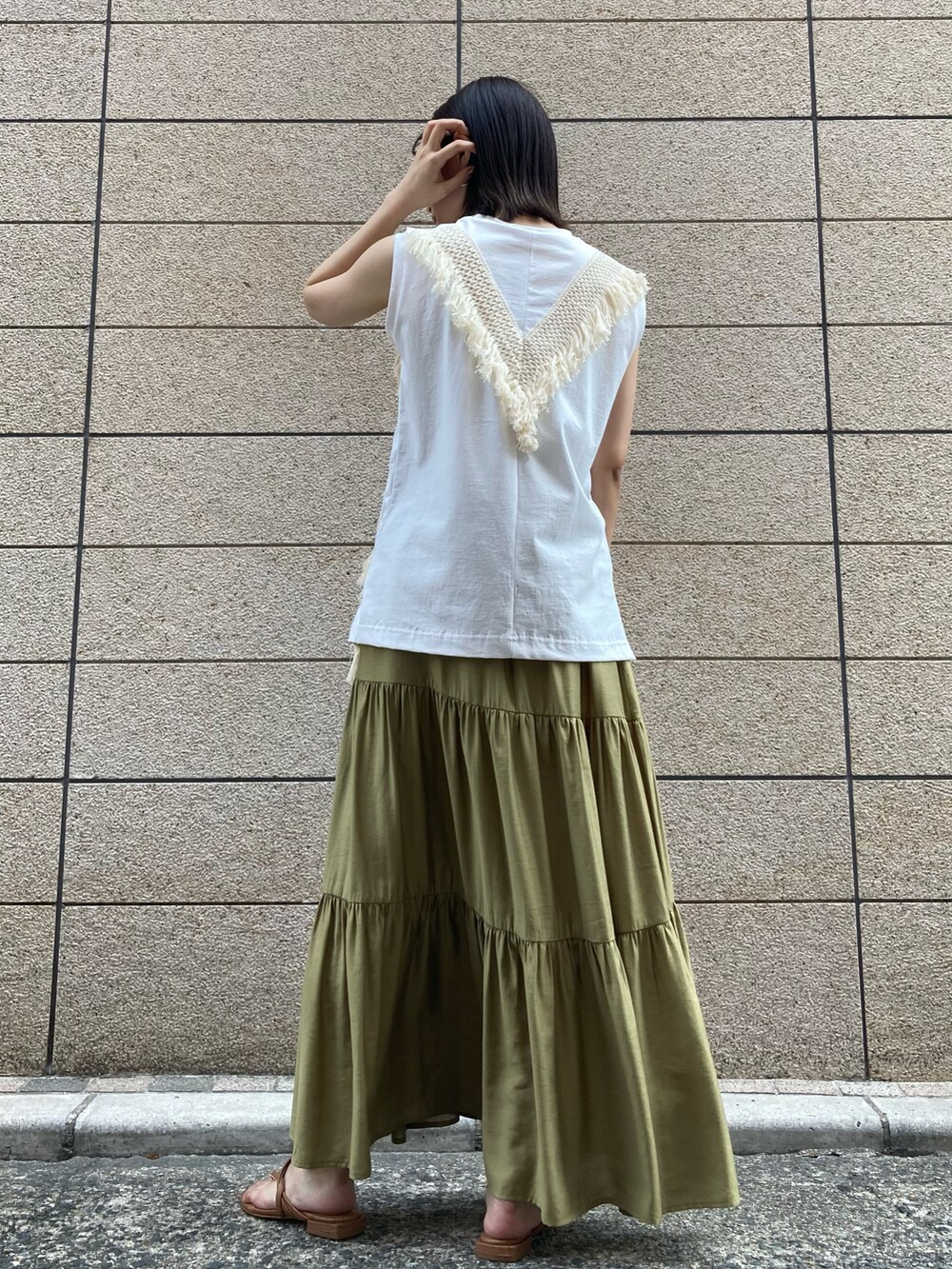 ホワイト系のトップス、グリーン系のスカート、ブラウン系のサンダルを着用したレディースの夏コーディネートの4枚目の写真
