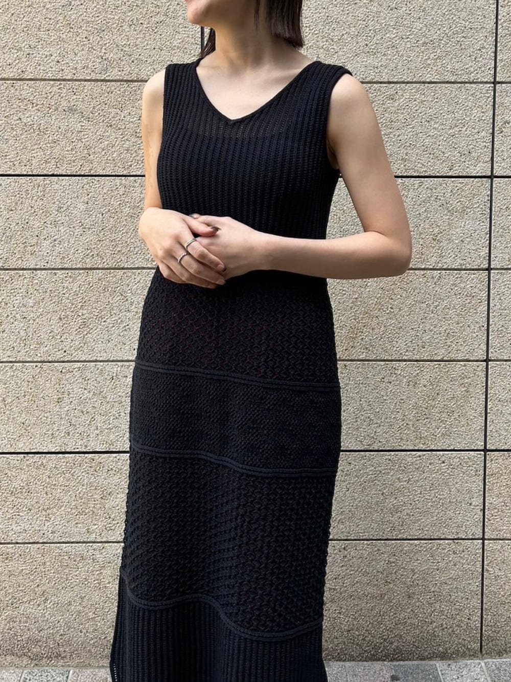 ピンク系のパンツ、ブラック系のニット/セーター、ブラック系のワンピースを着用したレディースの春コーディネートの4枚目の写真