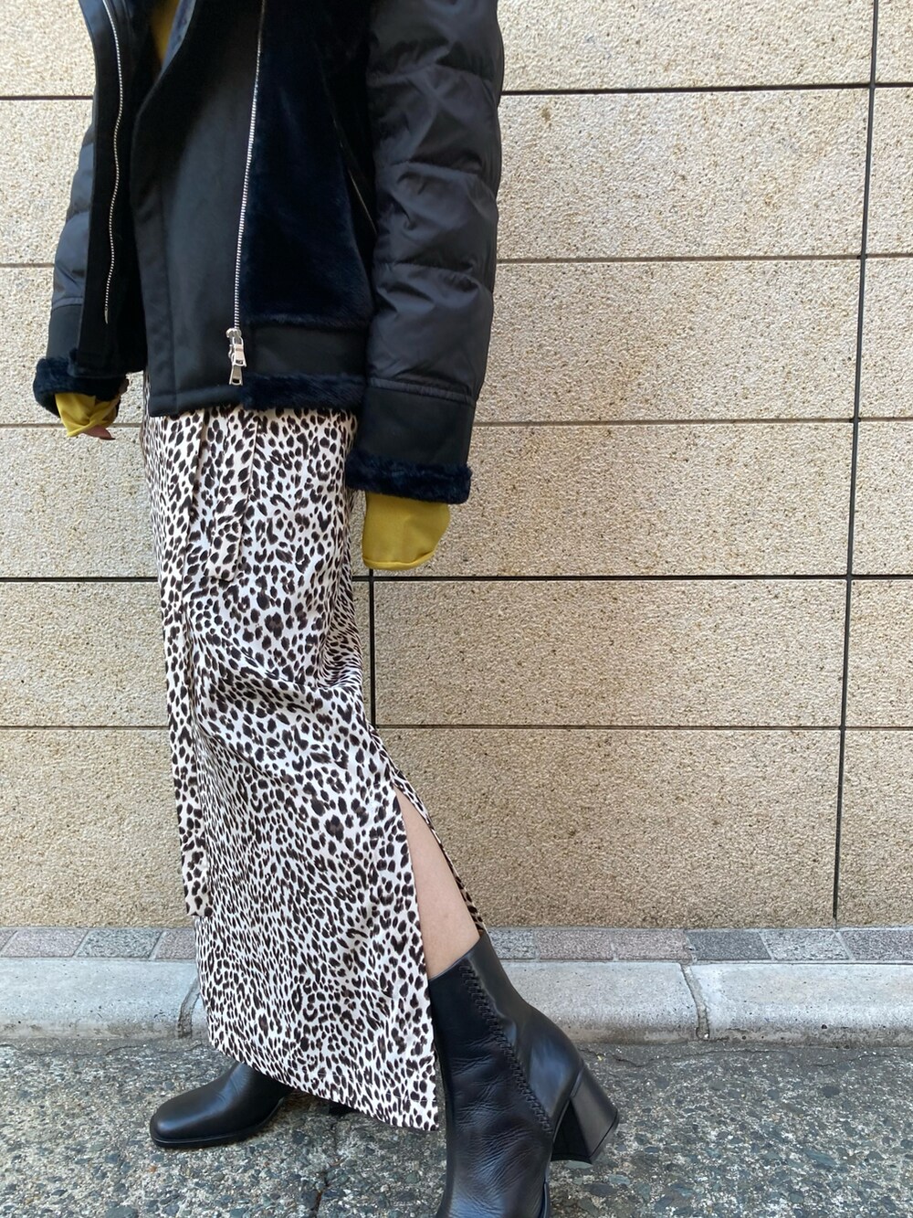 ブラック系のブルゾン、ベージュ系のスカート、ブラック系のブーツを着用したレディースの秋コーディネートの4枚目の写真