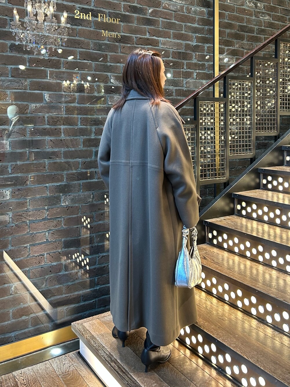 ブラウン系のチェスターコート、イエロー系のニット/セーター、ブラック系のその他パンツを着用したレディースの秋コーディネートの3枚目の写真