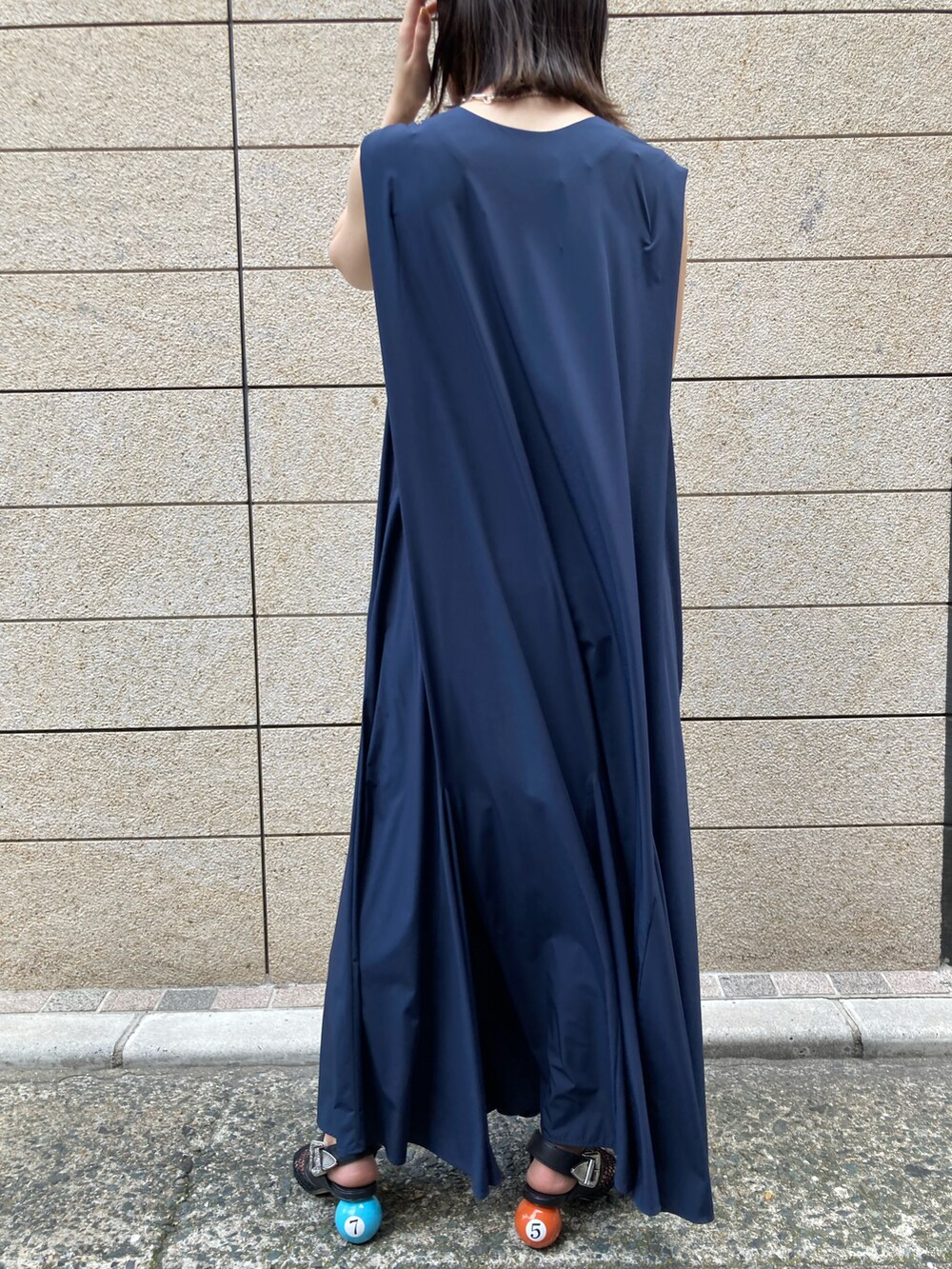 ブルー系のワンピース、ブラック系のサンダル、シルバー系のイヤリングを着用したレディースの夏コーディネートの3枚目の写真