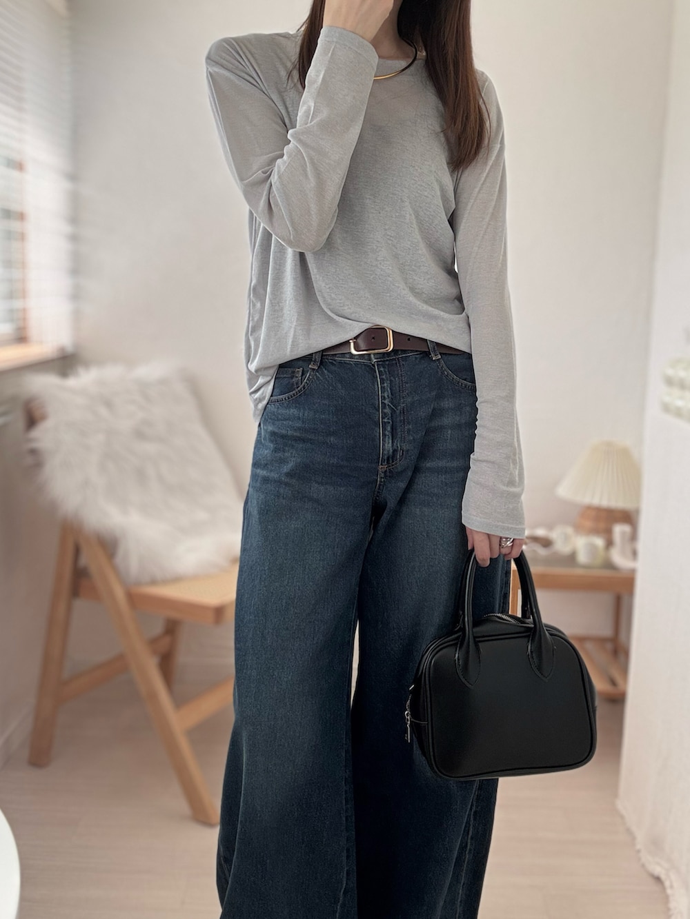 グレー系のTシャツ/カットソー、ブルー系のデニムパンツ、ブラック系のキャミソールを着用したレディースの秋コーディネートの3枚目の写真