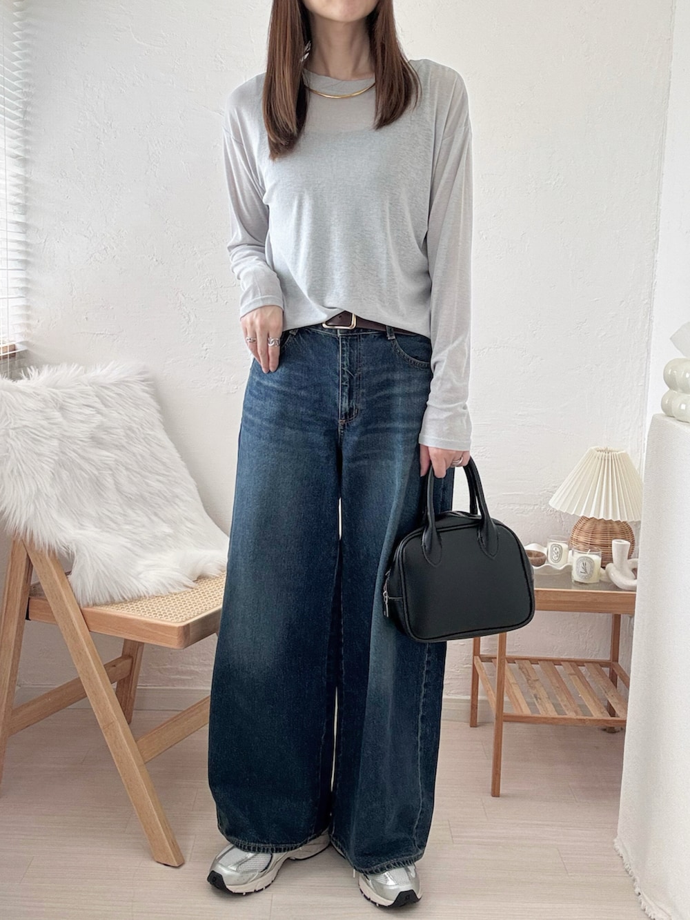 グレー系のTシャツ/カットソー、ブルー系のデニムパンツ、ブラック系のキャミソールを着用したレディースの秋コーディネートの2枚目の写真
