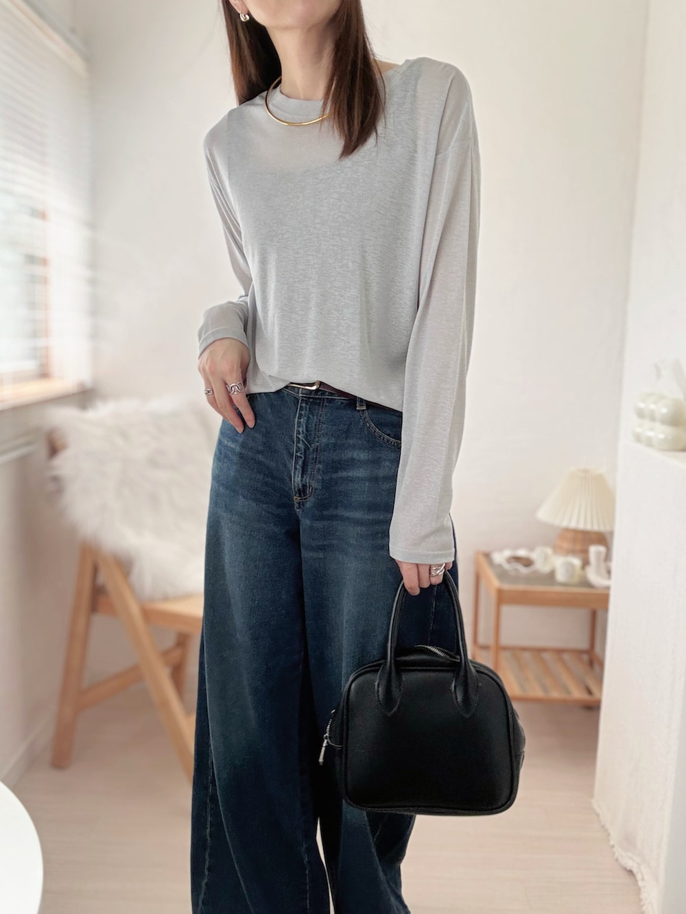 グレー系のTシャツ/カットソー、ブルー系のデニムパンツ、ブラック系のキャミソールを着用したレディースの秋コーディネートの4枚目の写真