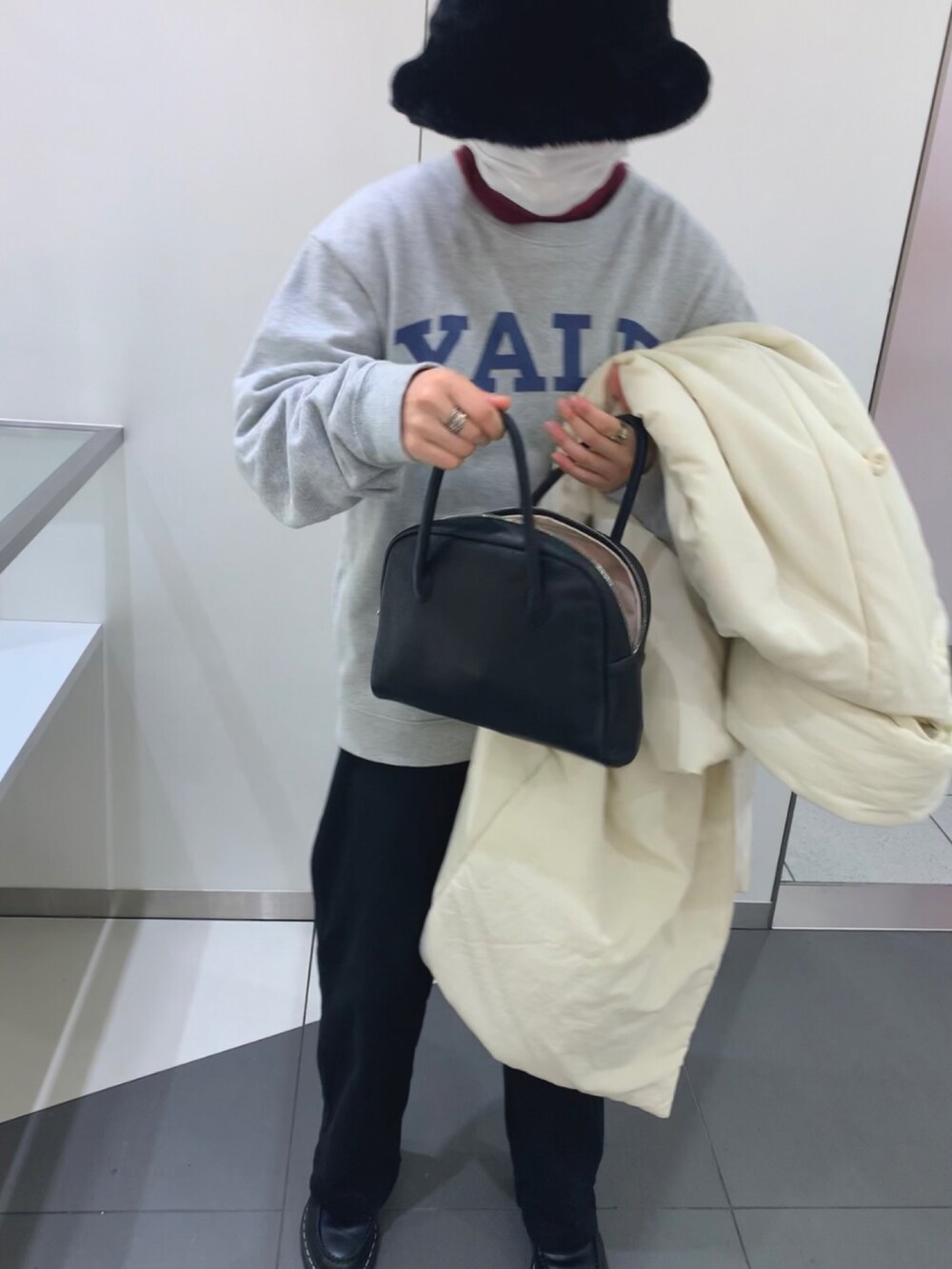 ホワイト系のジャケット/アウター、ブラック系のローファー、ブラック系のチノパンツを着用したレディースの冬コーディネートの2枚目の写真