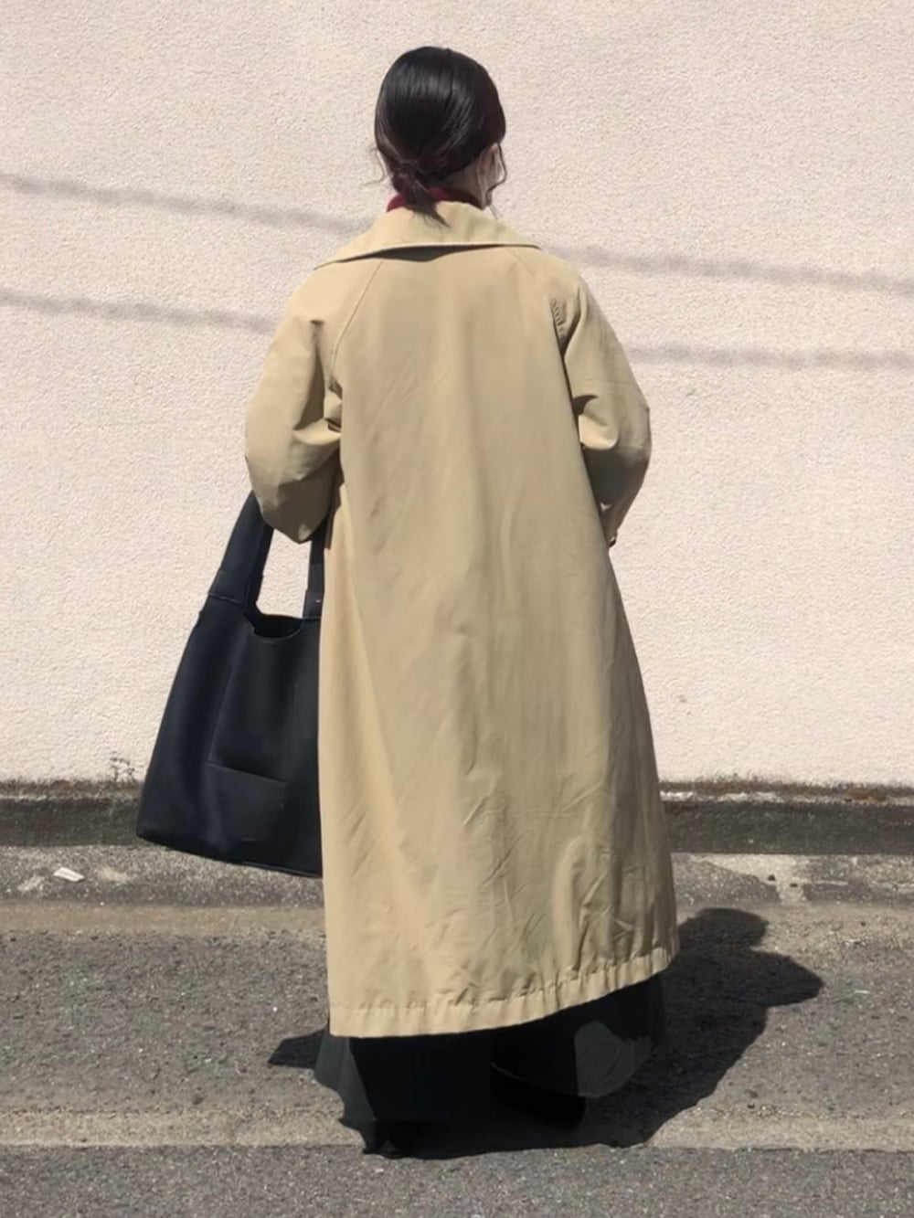 ブラック系のトートバッグ、ブラック系のパンツ、ブルー系のデニムジャケットを着用したレディースの春コーディネートの2枚目の写真