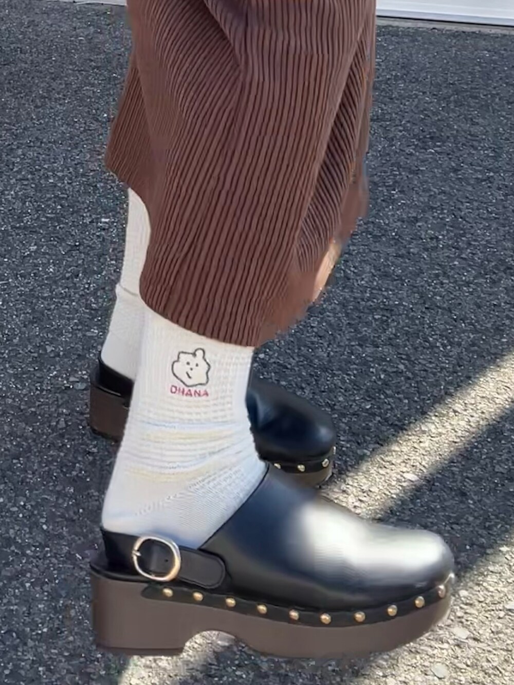 ブラック系のバッグ、ブラウン系のワンピース、ブラック系のシューズを着用したレディースの春コーディネートの2枚目の写真