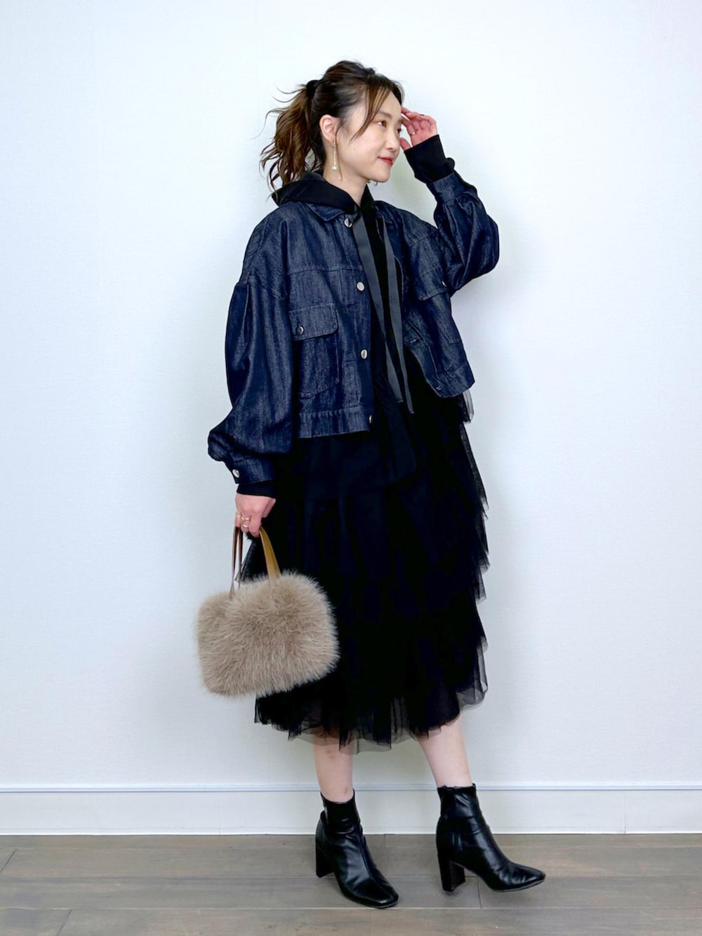 ブルー系のデニムジャケット、ブラック系のワンピースを着用したレディースの冬コーディネートの2枚目の写真