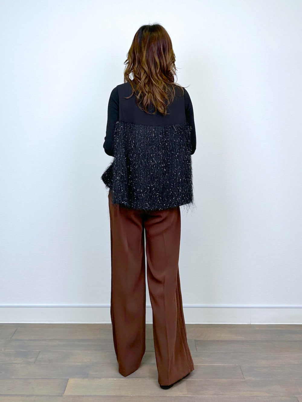 ブラウン系のスラックス、ブラック系のシャツ/ブラウス、ブラック系のニット/セーターを着用したレディースの冬コーディネートの3枚目の写真