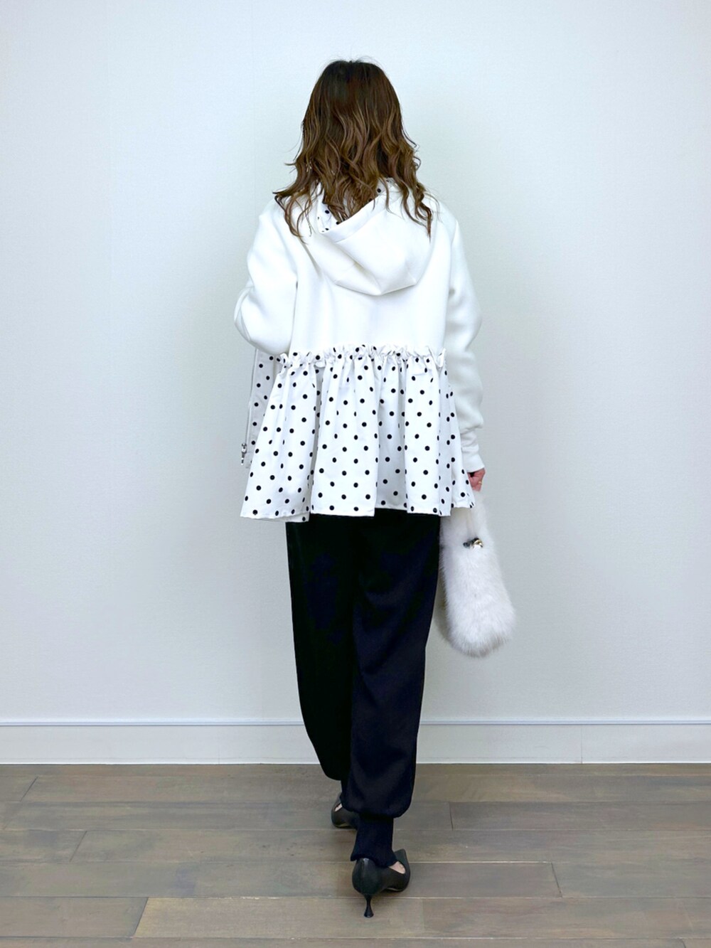 シルバー系のニット/セーター、ブラック系のその他パンツ、ホワイト系のパーカーを着用したレディースの冬コーディネートの3枚目の写真